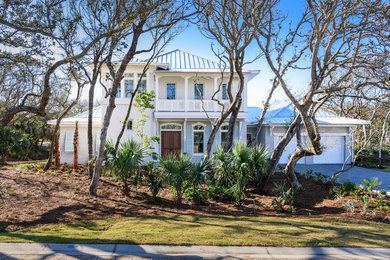 Large coastal white two-story stucco house exterior idea in Jacksonville with a metal roof