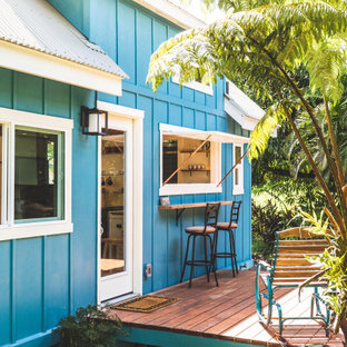 Imagen de fachada de casa azul, costera, pequeña, de dos plantas, con revestimiento de madera, tejado a dos aguas y tejado de metal