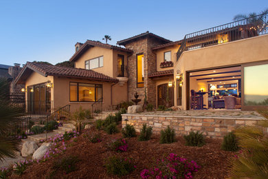 Example of a mid-sized tuscan brown two-story stucco exterior home design in San Diego
