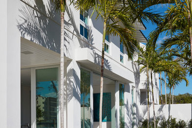Inspiration for a large and white contemporary two floor house exterior in Miami with a pitched roof.