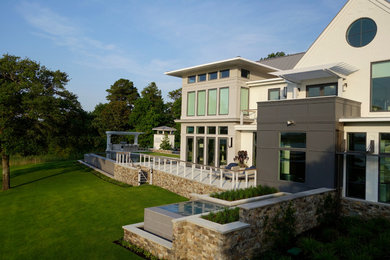 Ejemplo de fachada beige contemporánea grande de dos plantas con revestimientos combinados y tejado a dos aguas