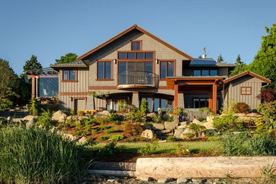 Cette image montre une grande façade de maison marron craftsman en bois à un étage avec un toit à deux pans.