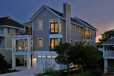 Example of a mid-sized beach style gray three-story concrete fiberboard exterior home design in Other with a shingle roof