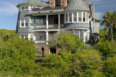 This is an example of a large and blue victorian house exterior in Charleston with three floors and wood cladding.