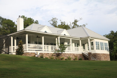 This is an example of a large and white world-inspired detached house in Other with a hip roof and a metal roof.