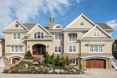 Example of a beach style beige three-story wood exterior home design in New York