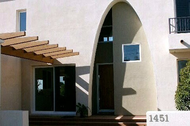 Foto de fachada beige de estilo americano de tamaño medio de dos plantas con revestimiento de estuco y tejado plano