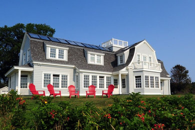 Imagen de fachada blanca clásica extra grande de dos plantas con revestimiento de madera y tejado a dos aguas