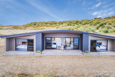 Inspiration pour une façade de maison multicolore marine de plain-pied avec un toit en métal.