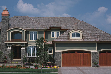 Design ideas for a large and green classic two floor house exterior in Minneapolis with mixed cladding and a hip roof.