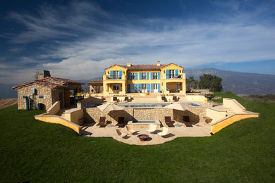 サンタバーバラにあるシャビーシック調のおしゃれな家の外観 (漆喰サイディング、黄色い外壁) の写真