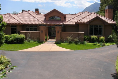 Example of a huge tuscan beige one-story stucco house exterior design in Denver with a hip roof and a tile roof