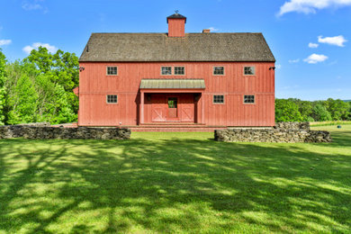 Inspiration for a large farmhouse red two-story wood exterior home remodel in New York with a shingle roof