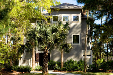 Example of a classic gray three-story wood exterior home design in Charleston with a hip roof