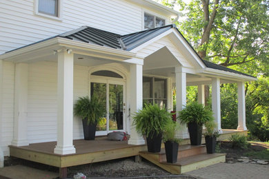 Foto de fachada de casa blanca clásica de tamaño medio de dos plantas con revestimiento de vinilo, tejado a dos aguas y tejado de metal