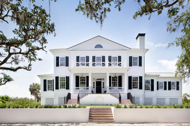 Inspiration for a large timeless white two-story house exterior remodel in Tampa with a metal roof