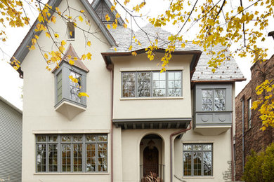 Idée de décoration pour une façade de maison beige tradition à deux étages et plus et de taille moyenne.
