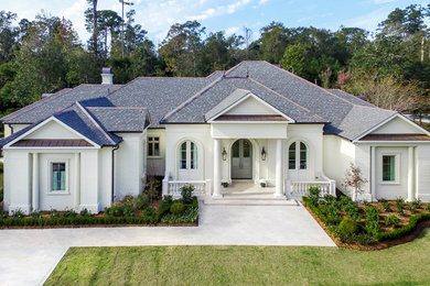 Large traditional white one-story stone gable roof idea in New Orleans