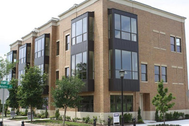 Contemporary brown three-story brick exterior home idea in Dallas