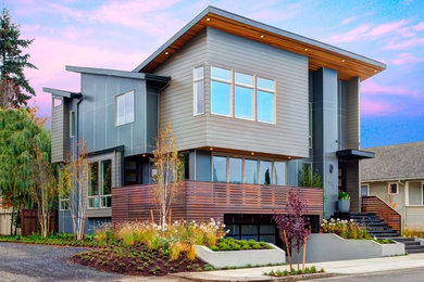 Large trendy gray three-story mixed siding exterior home photo in Portland with a shed roof