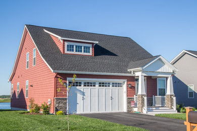 Modelo de fachada de casa roja actual de tamaño medio de dos plantas con revestimientos combinados y tejado de teja de madera
