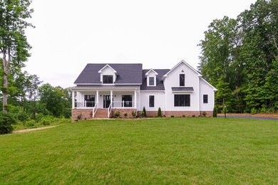 Example of a white two-story wood exterior home design in Richmond with a mixed material roof