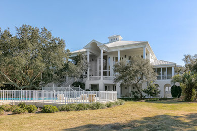 Photo of an expansive and white classic render house exterior in Miami with three floors and a pitched roof.