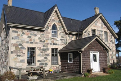Imagen de fachada gris tradicional de tamaño medio de dos plantas con revestimientos combinados y tejado a dos aguas