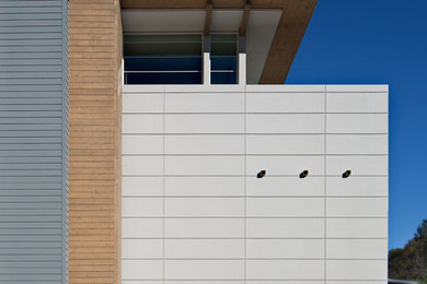 Diseño de fachada gris actual grande de tres plantas con tejado de un solo tendido y revestimientos combinados