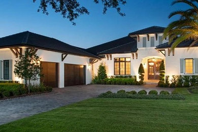 Large craftsman white one-story stucco house exterior idea in Orlando with a hip roof and a shingle roof