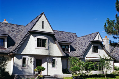 Foto de fachada de casa blanca tradicional de tamaño medio de dos plantas con revestimiento de estuco, tejado a dos aguas y tejado de teja de madera