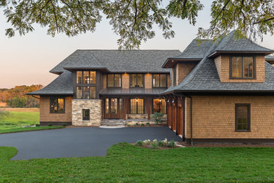 Пример оригинального дизайна: двухэтажный, коричневый частный загородный дом в классическом стиле с вальмовой крышей и крышей из гибкой черепицы