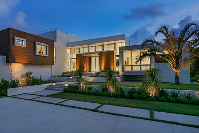 Ejemplo de fachada de casa blanca minimalista grande de dos plantas con revestimientos combinados y tejado plano