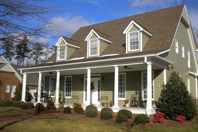 Inspiration for a mid-sized timeless green two-story vinyl exterior home remodel in Raleigh with a clipped gable roof