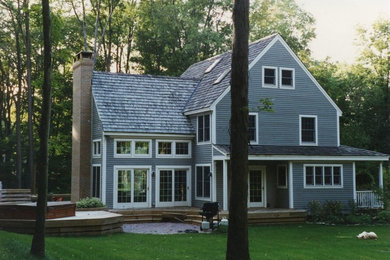 Ejemplo de fachada de casa azul tradicional de tamaño medio de dos plantas con revestimiento de madera, tejado a dos aguas y tejado de teja de madera
