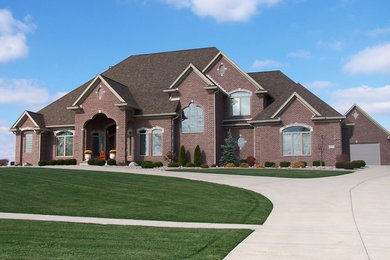 Huge tuscan brown two-story brick house exterior photo in Other with a hip roof and a shingle roof