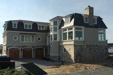 This is an example of a large and beige classic two floor detached house in Boston with mixed cladding, a hip roof and a shingle roof.