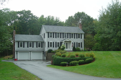 Modelo de fachada gris de estilo americano grande de tres plantas con tejado a dos aguas