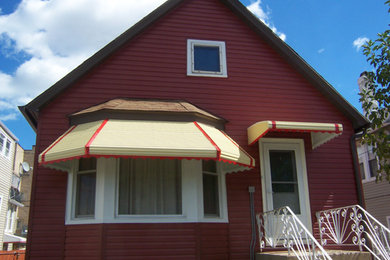 Diseño de fachada roja tradicional pequeña de dos plantas con revestimiento de vinilo