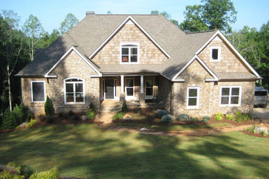 Example of a large classic beige two-story stone gable roof design in Atlanta