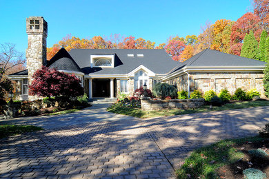 Example of a mid-sized classic brown one-story stone exterior home design in DC Metro with a shingle roof