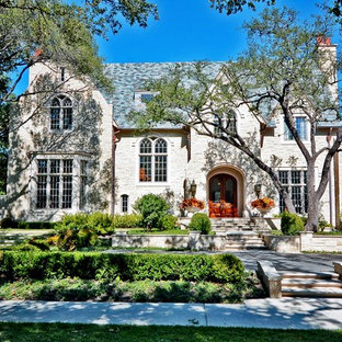 Large traditional beige two-story stone exterior home idea in Dallas with a shingle roof
