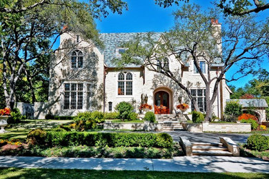 Large traditional beige two-story stone exterior home idea in Dallas with a shingle roof