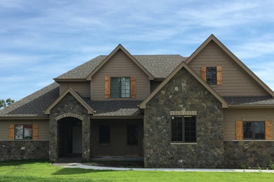 Idée de décoration pour une façade de maison marron tradition de taille moyenne et à un étage avec un revêtement mixte, un toit à deux pans et un toit en shingle.