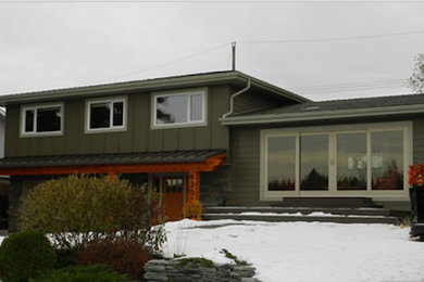 Photo of a medium sized and green traditional split-level house exterior in Edmonton with metal cladding.