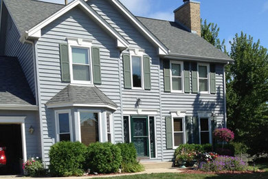 This is an example of a large and blue two floor house exterior in Milwaukee with wood cladding.