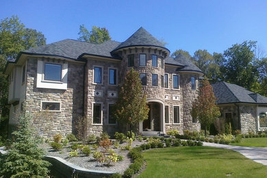 Example of a large classic brown two-story stone exterior home design in Other