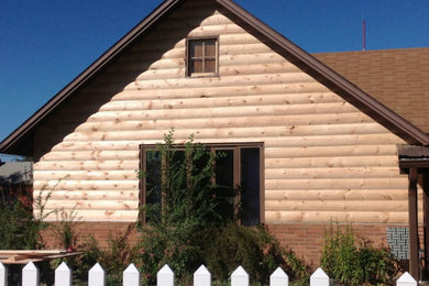 This is an example of a medium sized and beige rural two floor house exterior in Philadelphia with wood cladding.