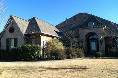 Inspiration for a large beige two-story stone exterior home remodel in Oklahoma City