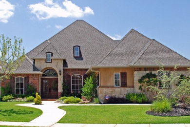 Example of a classic beige two-story mixed siding exterior home design in Oklahoma City with a shingle roof